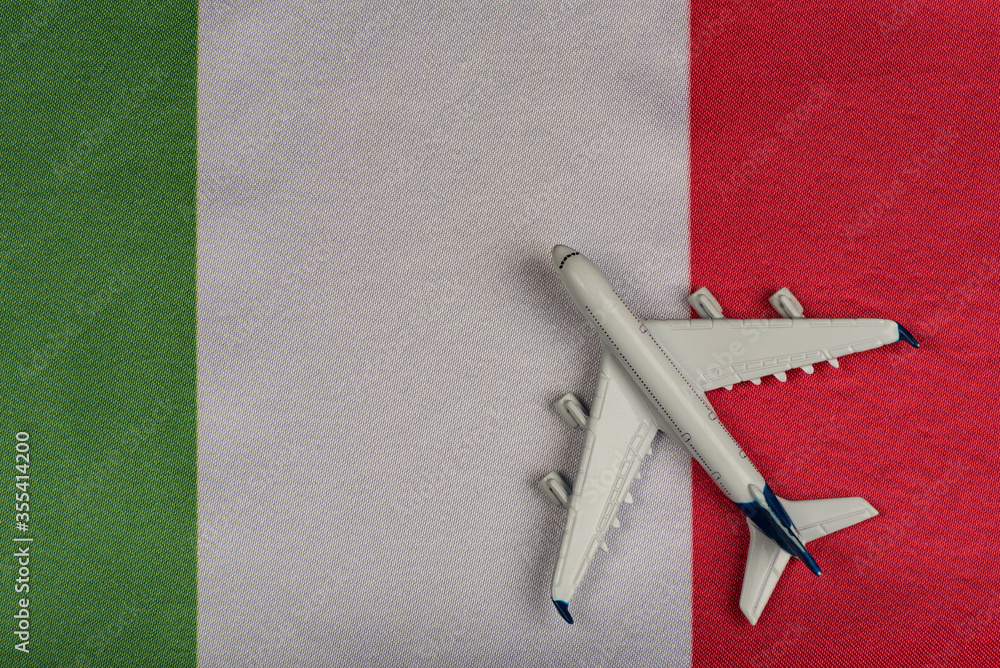 Flag of Italy and model airplane. Resumption of flights after quarantine. Flights to Italy Flag of Italy and model airplane. Resumption of flights after quarantine. Flights to Italy