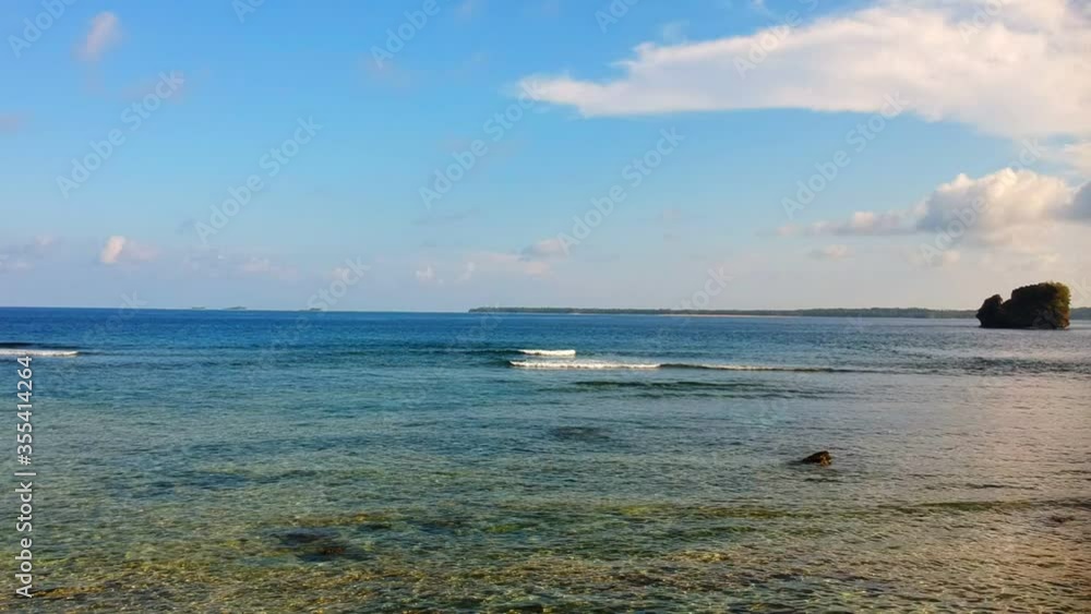 Seashore with foamy waves and isolated small island Seashore with foamy waves and isolated small island