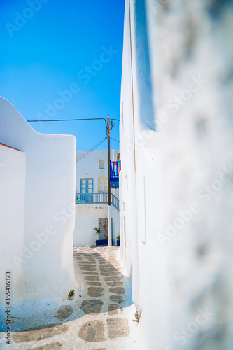 Fototapeta Naklejka Na Ścianę i Meble -  The narrow streets of the island with blue balconies, stairs and flowers.