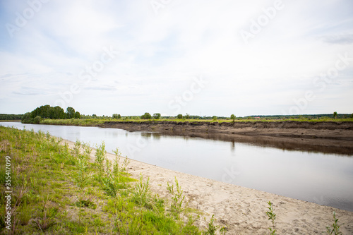 View of the Tara river, Omsk region, Siberia, Russia. Surroundings of the Siberian expanses. Picturesque view on the steep Bank of the river.