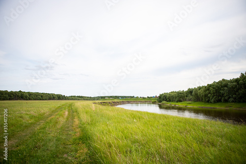 View of the Tara river, Omsk region, Siberia, Russia. Surroundings of the Siberian expanses. Picturesque view on the steep Bank of the river.