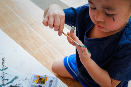 Funny little boy with painted hand