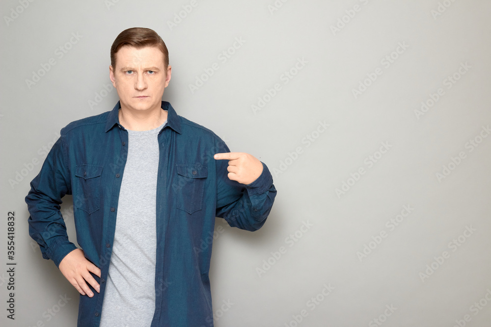 Portrait of serious mature man pointing with index finger at himself Portrait of serious mature man pointing with index finger at himself