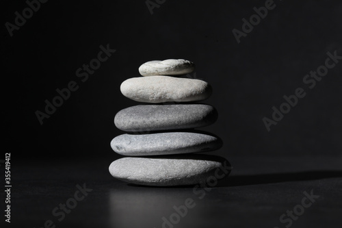 Canvas Print piled zen stones   isolated on black background with copy space for your text