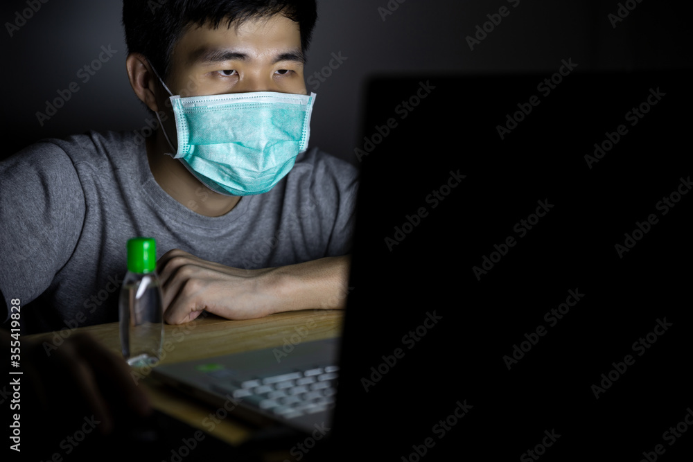 Asian man work from home and wear a protective medical mask. Clean his hands with sanitizer alcohol gel to prevent Coronavirus (CoVID-19) outbreak. Asian man work from home and wear a protective medical mask. Clean his hands with sanitizer alcohol gel to prevent Coronavirus (CoVID-19) outbreak.