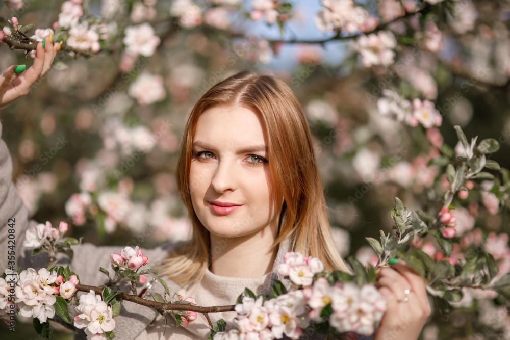 Young girl in a blooming apple orchard