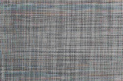 Light grey background. Geometric pattern. Woven material. Horizontal and vertical threads. Wicker decorative surface.