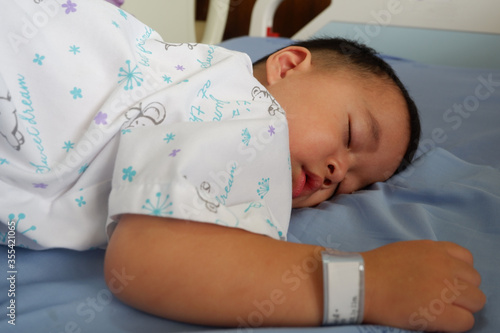 The sick boy was sleeping in a hospital bed. Boy is sick with Respiratory Syncytial Virus.