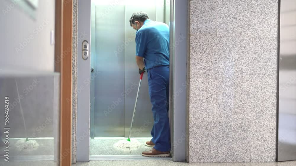 cleaning professional scrubbing the elevator floor with cleaning products cleaning professional scrubbing the elevator floor with cleaning products