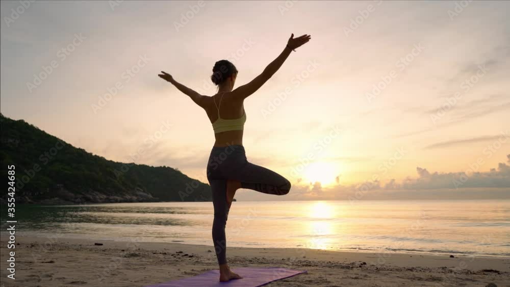Doing yoga at sunrise, the girl practices the yoga tree pose, the harmony of the body with nature. Doing yoga at sunrise, the girl practices the yoga tree pose, the harmony of the body with nature.