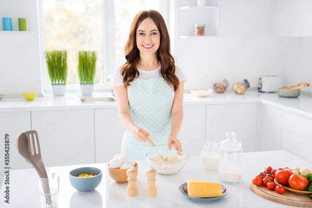 Photo of beautiful housewife chef enjoy morning cooking tasty cake cookies recording video for blog quarantine stay home hobby time wear apron stand modern kitchen indoors Photo of beautiful housewife chef enjoy morning cooking tasty cake cookies recording video for blog quarantine stay home hobby time wear apron stand modern kitchen indoors