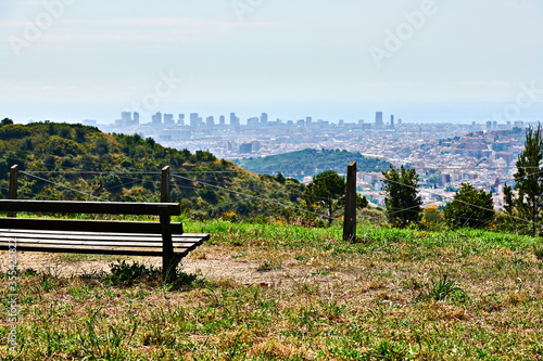 Vista de Barelona desde colina, parque con banco photo