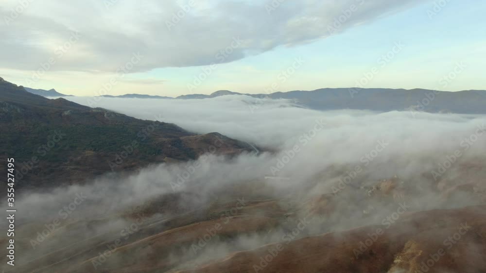 aerial drone fog lies in the valley between the mountain ranges of autumn aerial drone fog lies in the valley between the mountain ranges of autumn