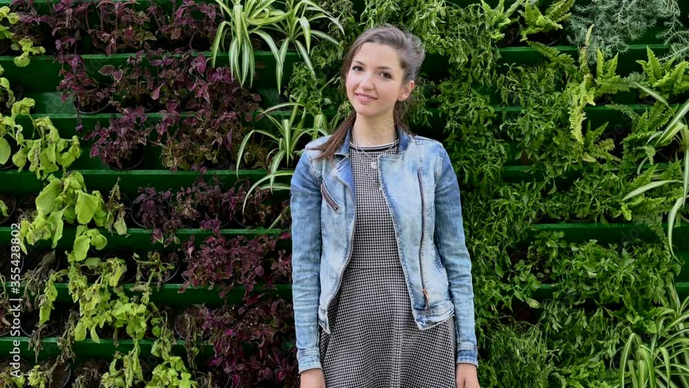 Portrait of a young girl on a background of green plants Portrait of a young girl on a background of green plants