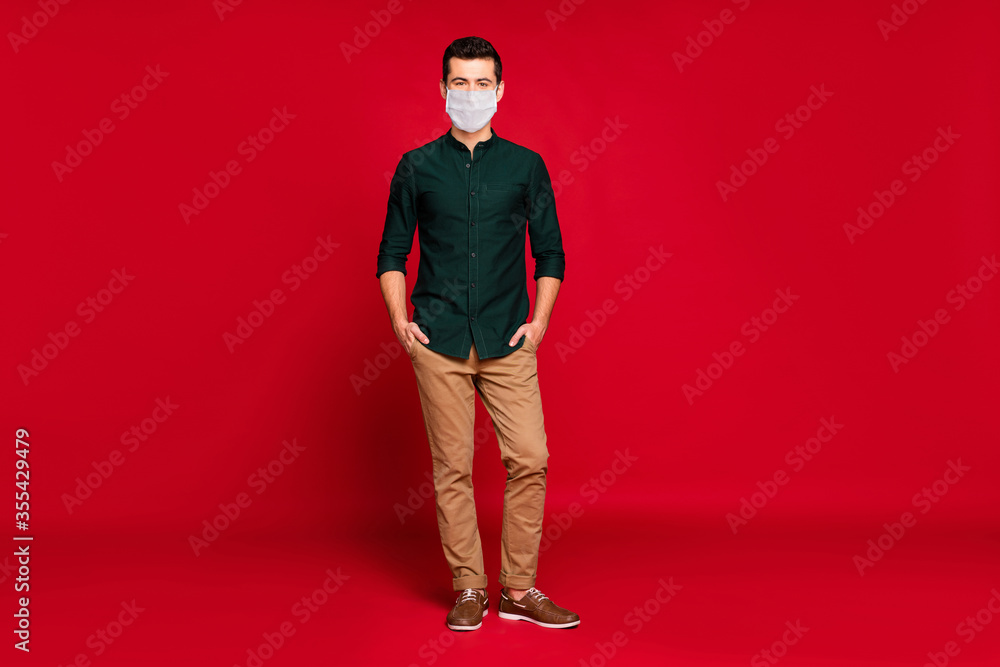 Full length body size view of his he nice attractive guy wearing safety gauze mask stop cov prevention risk disease sickness illness isolated bright vivid shine vibrant red color background Full length body size view of his he nice attractive guy wearing safety gauze mask stop cov prevention risk disease sickness illness isolated bright vivid shine vibrant red color background