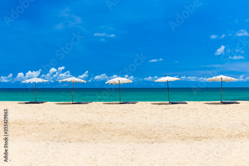 Fototapeta Naklejka Na Ścianę i Meble -  Beach umbrella on beach with blue sky, Phuket Thailand