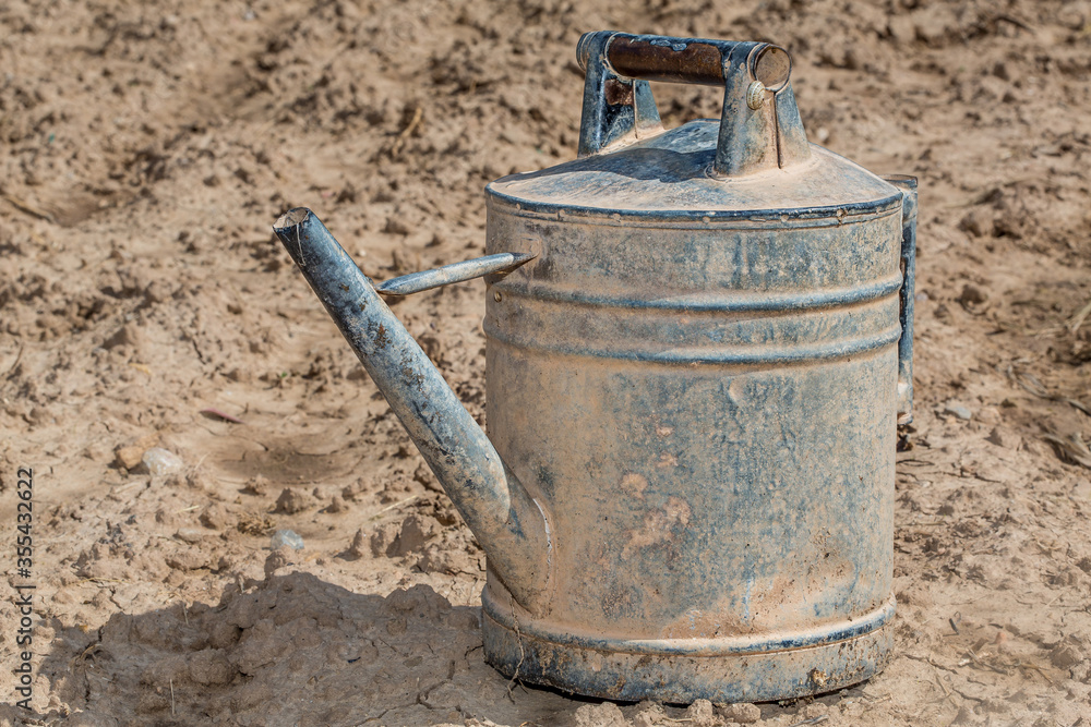 old metal watering can in the field old metal watering can in the field