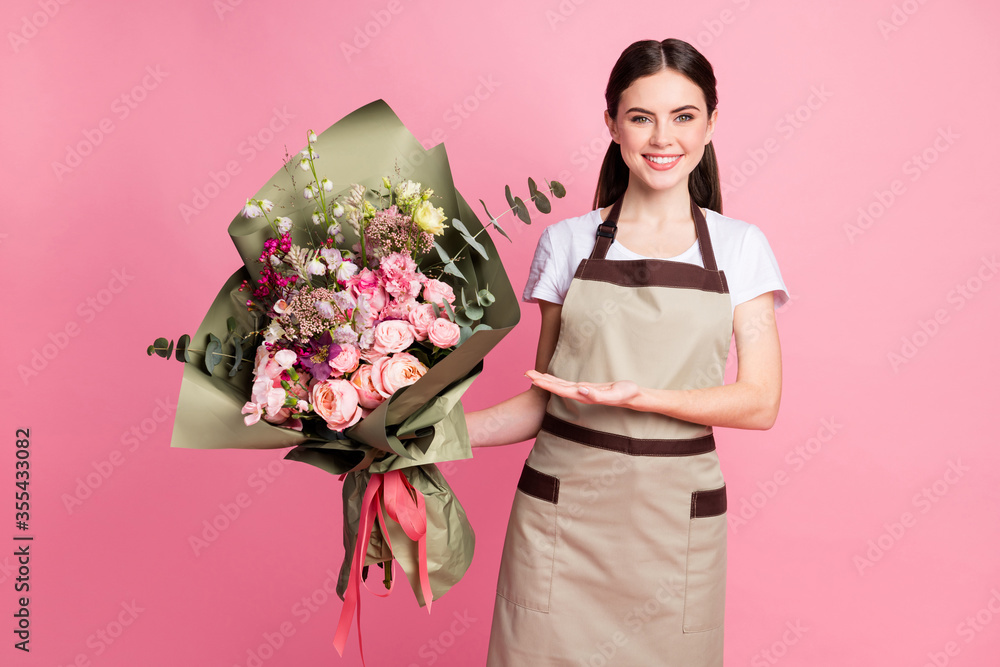 Portrait of her she nice attractive lovely pretty cheerful cheery girl shop owner holding in hands presenting bunch flowers to customer client isolated over pink pastel color background Portrait of her she nice attractive lovely pretty cheerful cheery girl shop owner holding in hands presenting bunch flowers to customer client isolated over pink pastel color background