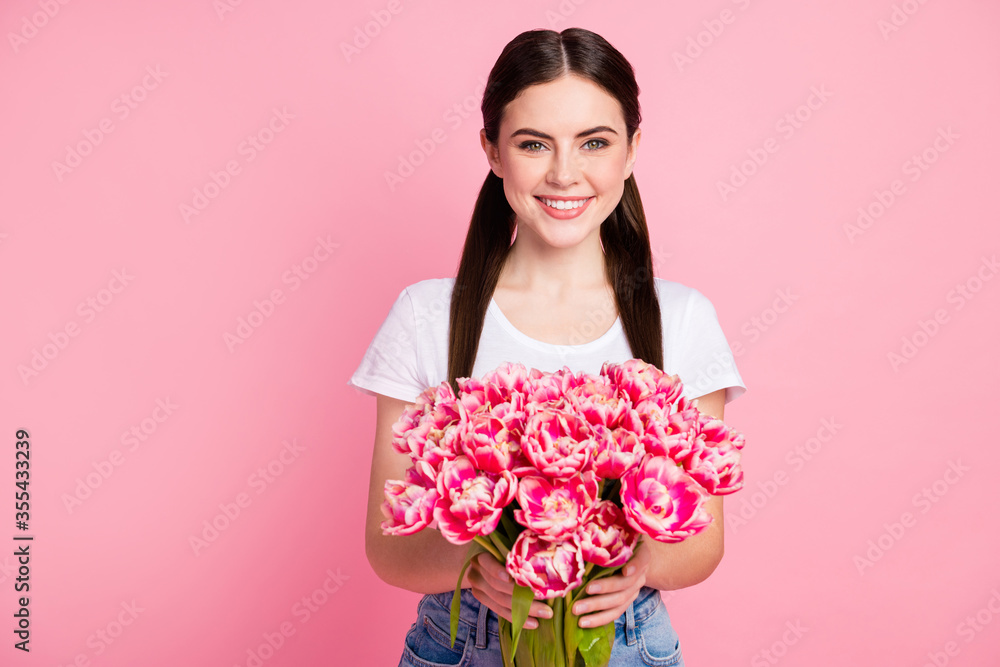 Close-up portrait of her she nice attractive lovely pretty charming cheerful cheery girl holding in hands flowers shop boutique store isolated over pink pastel color background Close-up portrait of her she nice attractive lovely pretty charming cheerful cheery girl holding in hands flowers shop boutique store isolated over pink pastel color background