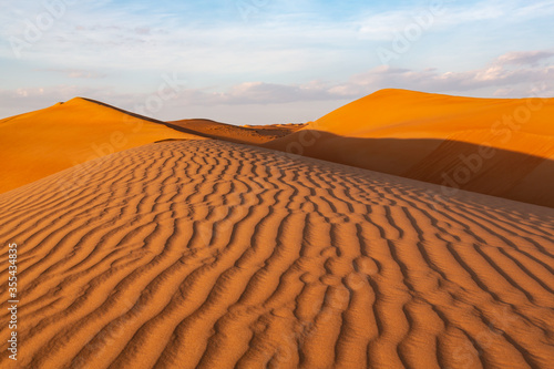 Fototapeta Impressive ripples in red dunes of Wahiba Sands desert in Oman in warm late afte