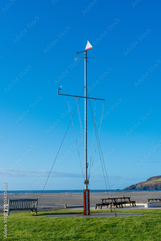 Nautical flag pole with weathervane and blue sky background located at Newport Boat Club, Newport, Pembrokeshire. Wales. UK Nautical flag pole with weathervane and blue sky background located at Newport Boat Club, Newport, Pembrokeshire. Wales. UK