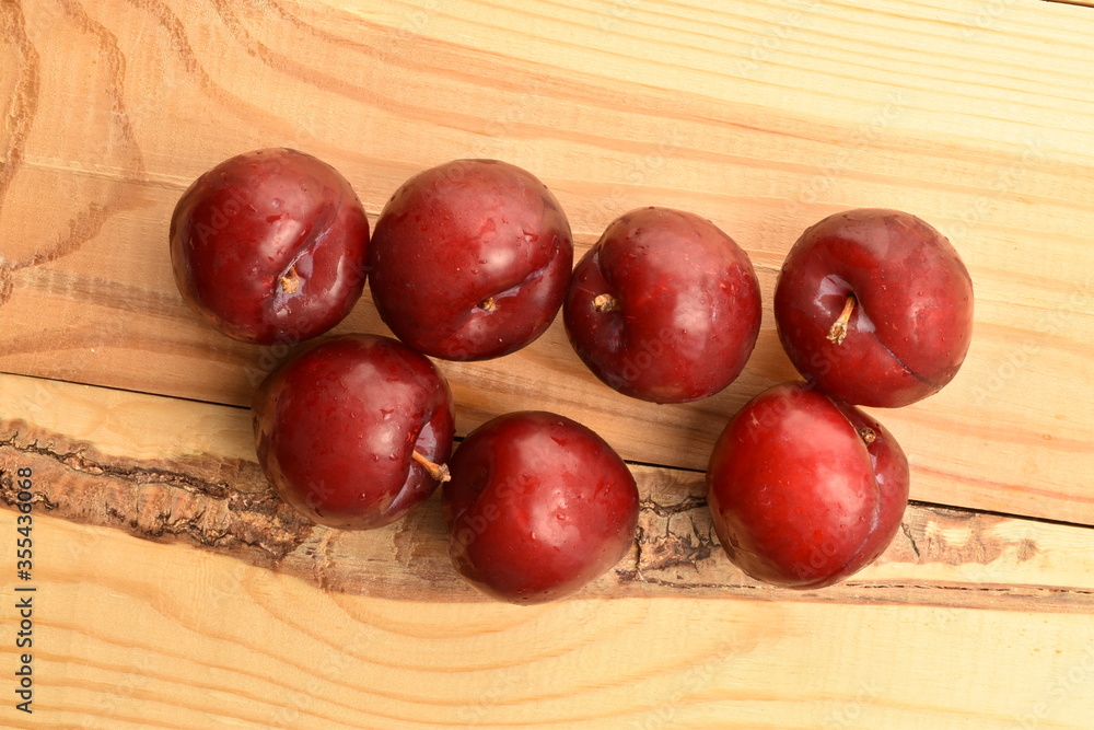 Juicy, tasty, organic red plum, close-up, on a wooden table. Juicy, tasty, organic red plum, close-up, on a wooden table.