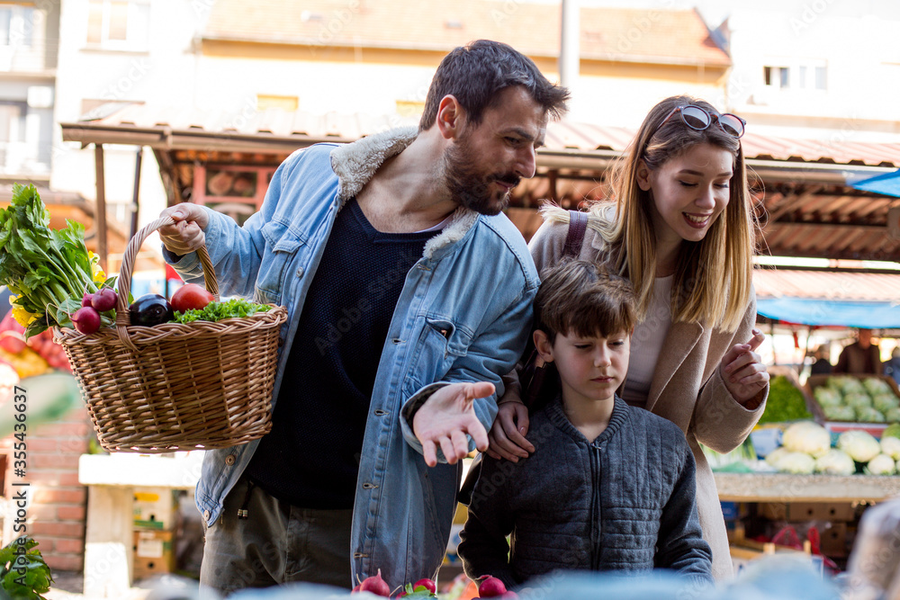 Obraz premium Beautiful family of three buying groceries