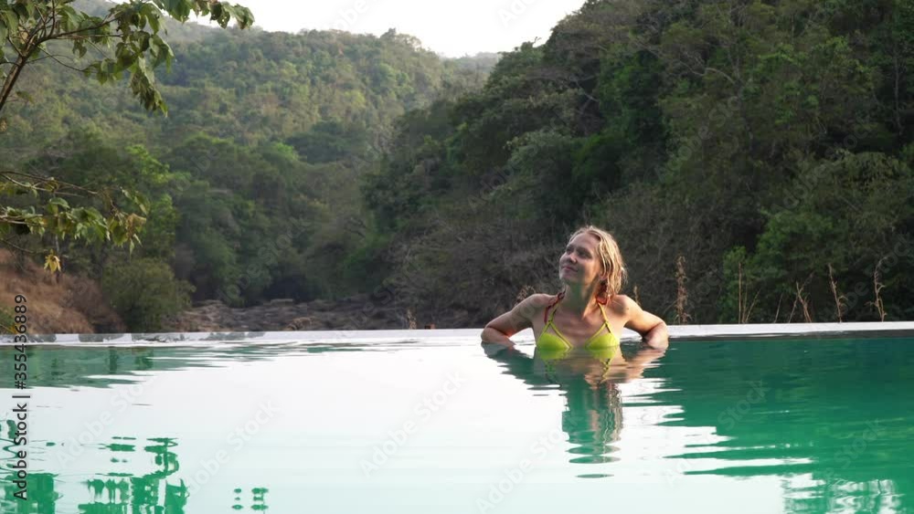 A young woman is relaxing and enjoying in an open-air pool A young woman is relaxing and enjoying in an open-air pool