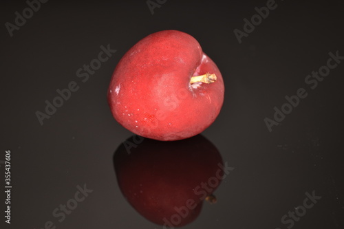 Juicy, tasty, organic red plum, close-up, on a black background.