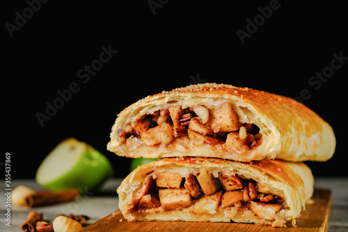  Traditional puff strudel with apple filling Two slices of apple strudel on a dark background. High quality illustration