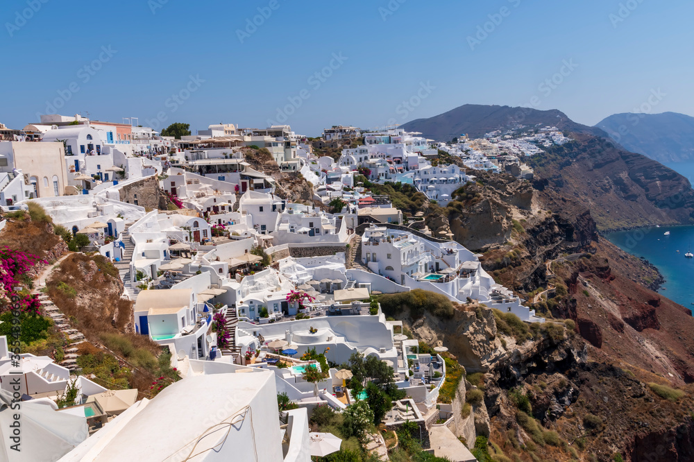 Beautiful view of fabulous picturesque village of Oia with traditional white houses and windmills in Santorini island, Greece
