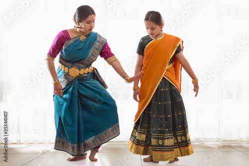 Bharatnatyam dancer teaching her young student. 
 photo
