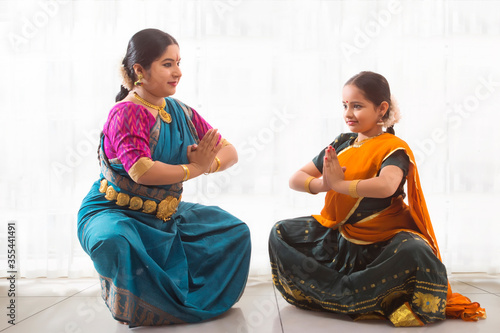 Young bharatnatyam dancer learning from her teacher. 
 photo