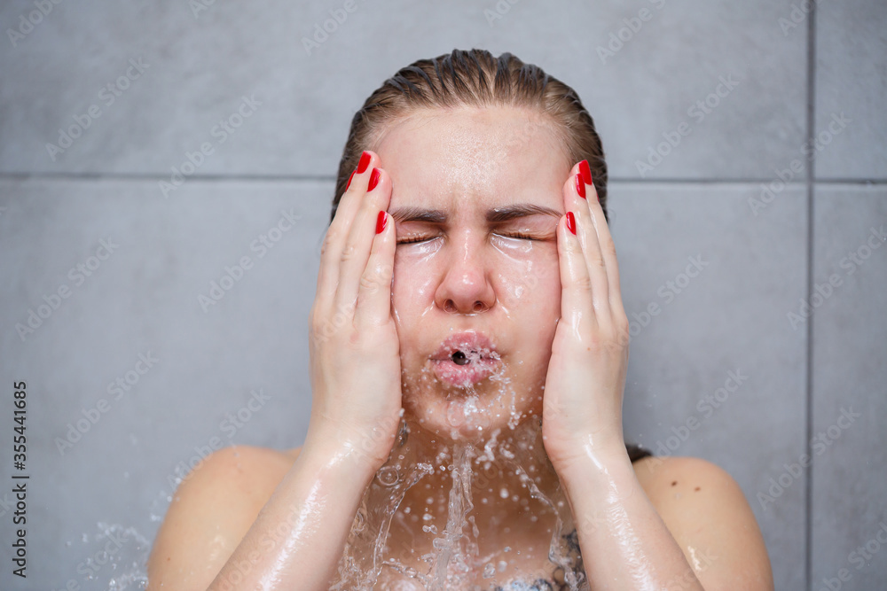 Facial skin care. Woman applying water by hands on face closeup. Girl washes her face with water, washing on a light background Facial skin care. Woman applying water by hands on face closeup. Girl washes her face with water, washing on a light background
