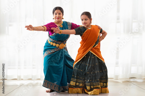 Young bharatnatyam dancer learning from her teacher. 
 photo