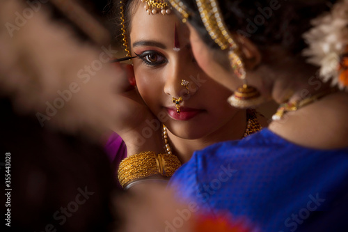 Bharatnatyam dancer applying kajal in her student’s eyes. 
