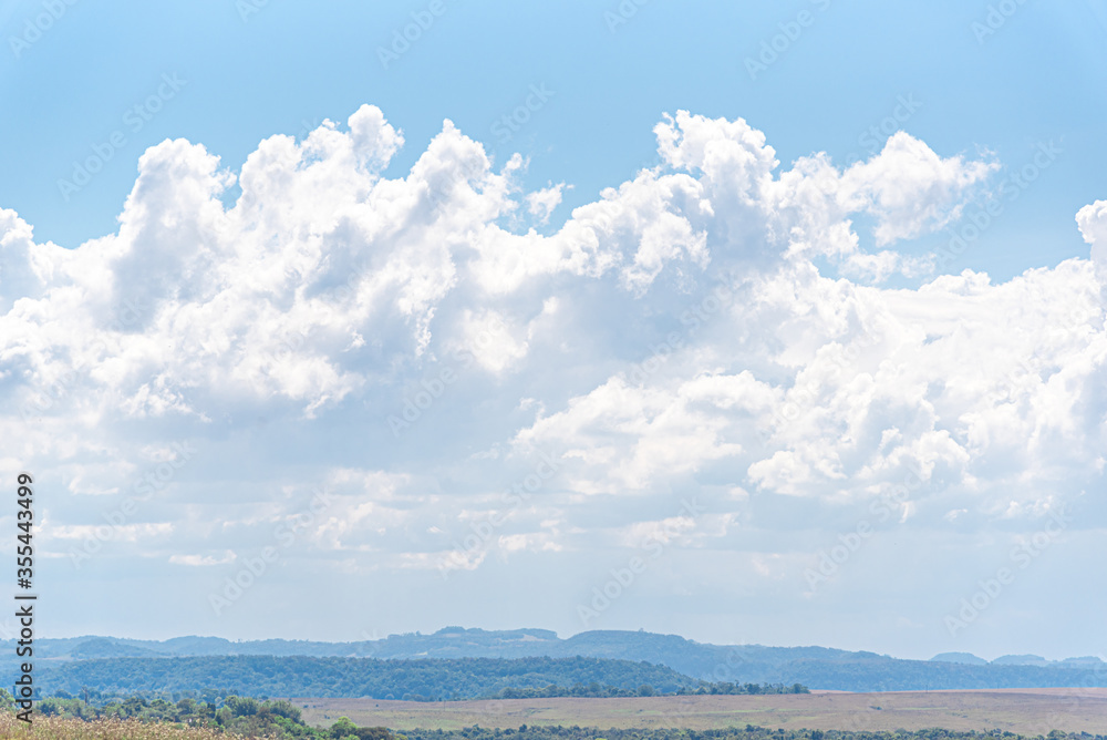 Fototapeta premium Rural landscape of the Pampa biome in Brazil and high cumulunimbus clouds in the background