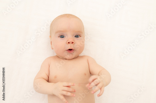 portrait of a child on a white background. Bedding for children. 6 months. Healthy baby in the crib. Space for text