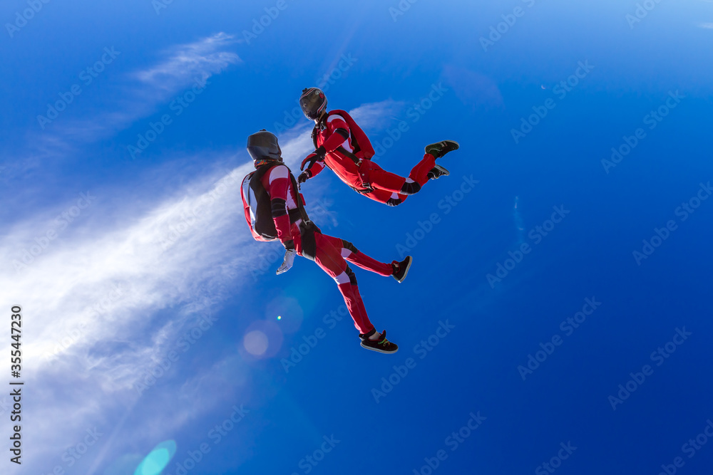 Two sports parachutist build a figure in free fall. Extreme sport concept.