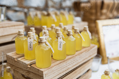 Fotografi Bottles of limoncello on wooden stands. Closed with corks.