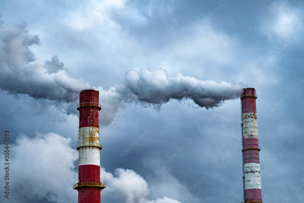Dark toxic smoke clouds coming out of factory chimney. Air pollution and global warming caused by old industrial power plant