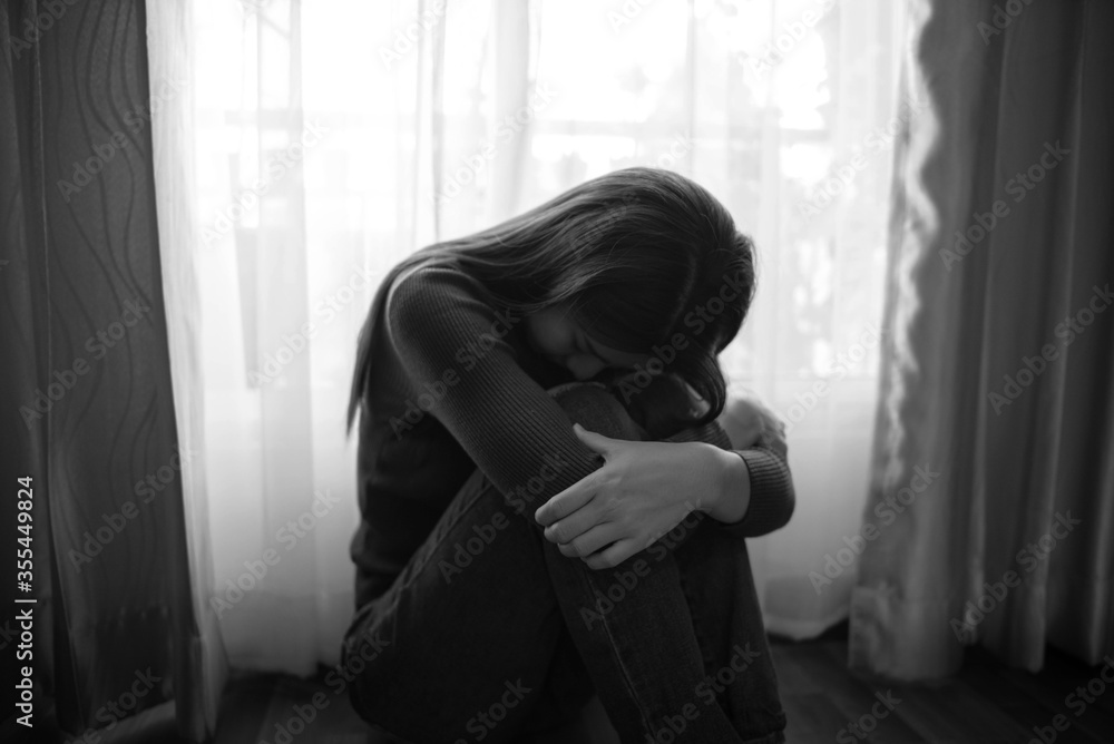 Sad and depressed young male sitting on the floor in the living room looking outside the doors,sad mood,feel tired, lonely and unhappy concept. Selective focus. Sad and depressed young male sitting on the floor in the living room looking outside the doors,sad mood,feel tired, lonely and unhappy concept. Selective focus.