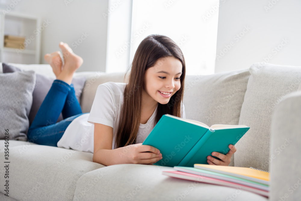 Photo of little pretty pupil school lady lying comfy sofa reading diary book positive good mood diligent student social distance quarantine home study comfort room indoors Photo of little pretty pupil school lady lying comfy sofa reading diary book positive good mood diligent student social distance quarantine home study comfort room indoors