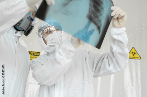 Doctors Epidemiologists examine x-ray for pneumonia of a Covid-19 patient. Coronavirus concept