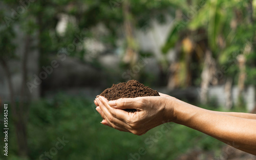 Hand holding fertile soil for plant to growing on nature background.