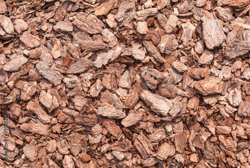 Close-up of red brown mulch made of pine bark. Concept of gardening and landscape decoration.