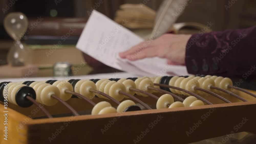Accounting Count Manually. A close-up of a worker’s hand counts on accounts. The other hand holds a sheet of notes Accounting Count Manually. A close-up of a worker’s hand counts on accounts. The other hand holds a sheet of notes