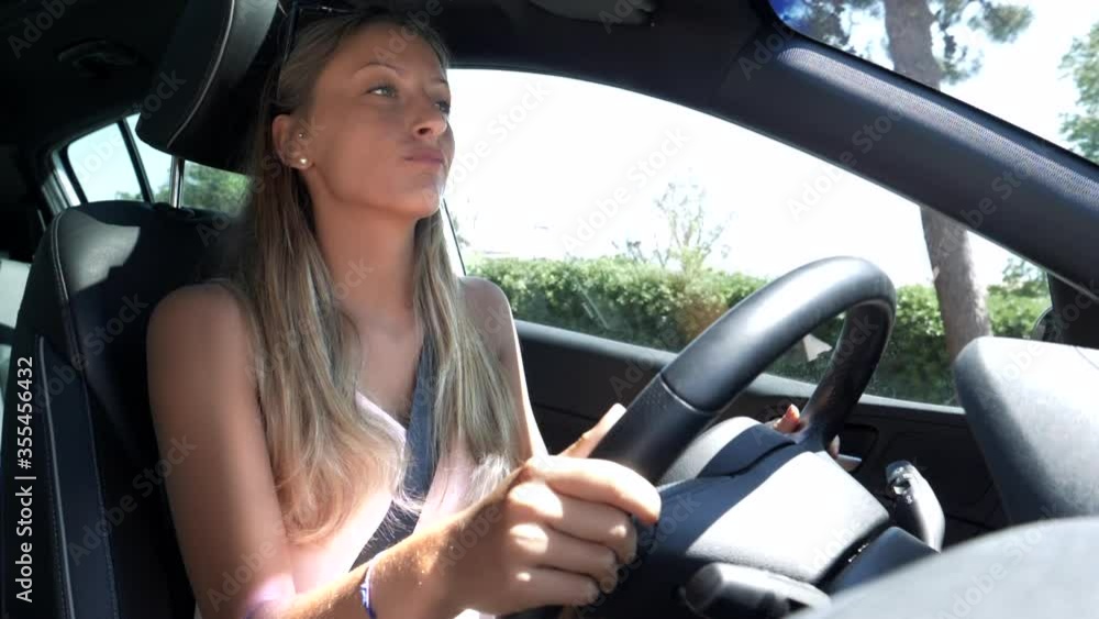 Young blonde woman feeling freedom after corona virus driving car listening music slow motion Young blonde woman feeling freedom after corona virus driving car listening music slow motion