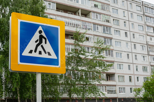 Pedestrian crossing sign on the background of a multi-storey building