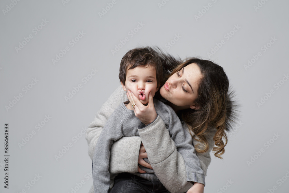 brother and sister pose in a playful setting in this conceptual image on grey background. Sibling friendship concept. Children of different ages. brother and sister pose in a playful setting in this conceptual image on grey background. Sibling friendship concept. Children of different ages.